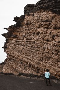 Rear view of woman standing on rock