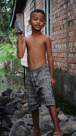 Portrait of young man standing against wall