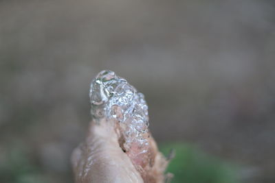 Close-up of hand against blurred water