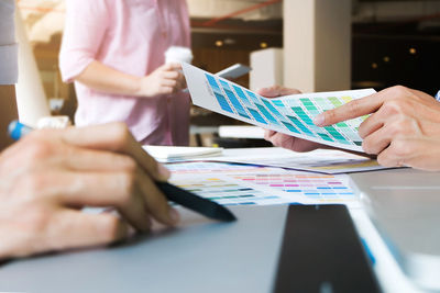 Business people discussing over color swatches at table