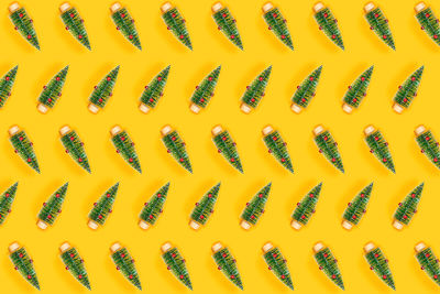 Christmas and new year yellow decorative pattern with green christmas trees. flat lay, top view.