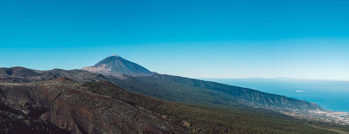 Scenic view of mountains against clear blue sky