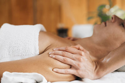 Midsection of woman lying on bed