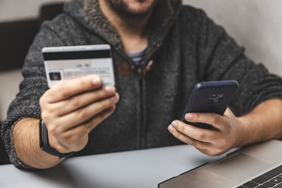 Midsection of man using mobile phone