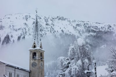 Panoramic view of snowcapped mountains and trees against sky
