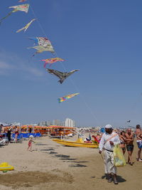 People at beach against clear sky