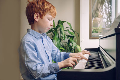 Boy playing piano at home