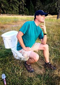 Midsection of man sitting in field