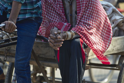 Low section of man holding woman standing in bus