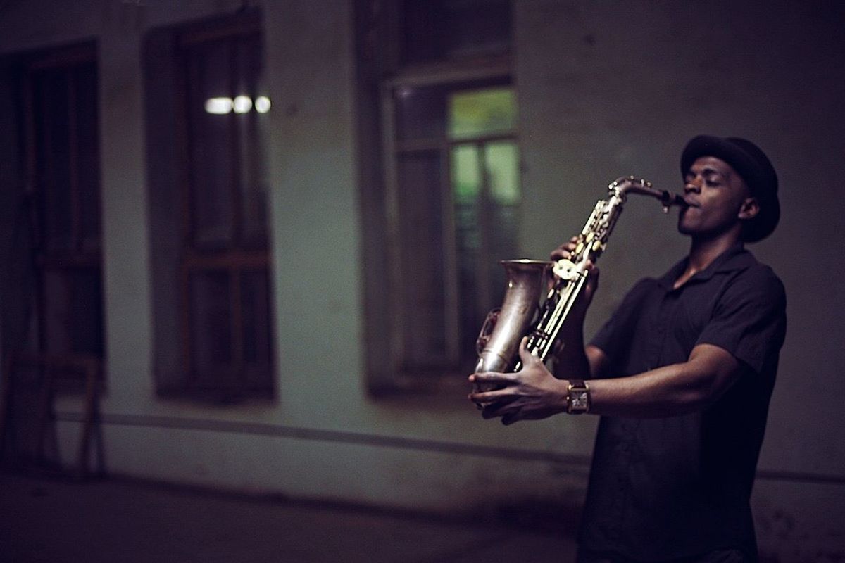 musical instrument, music, saxophone, musician, arts culture and entertainment, artist, playing, young adult, one person, real people, holding, saxophonist, performance, men, standing, young men, jazz music, skill, focus on foreground, wind instrument, brass, trumpet, entertainment occupation