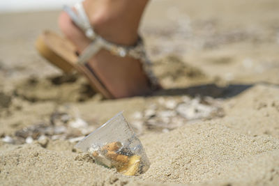 Close-up of hand on sand