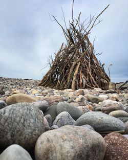 Rocks on landscape against cloudy sky