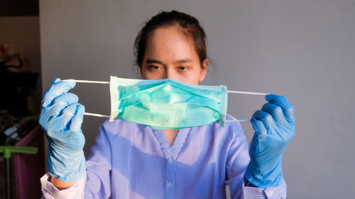 Portrait of mid adult woman holding face mask