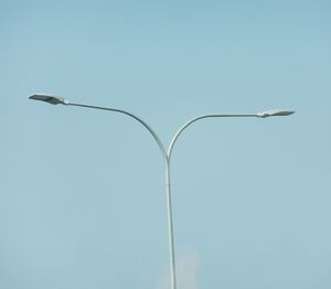 Low angle view of street light against blue sky