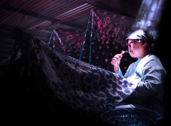 Side view of young man smoking outdoors