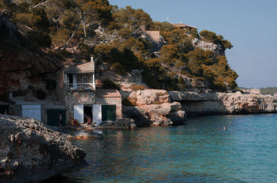 Buildings by sea against sky