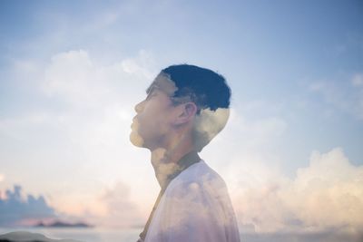 Double exposure of man and clouds