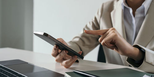 Midsection of man using laptop on table