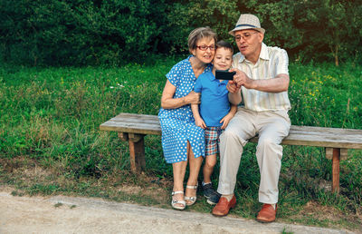 Full length of a smiling young woman sitting on bench