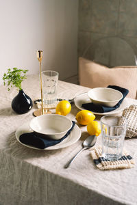 Vintage table setting with linen napkins and yellow lemons.