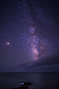 Scenic view of sea against star field at night