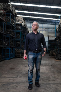 Portrait of young man standing against building