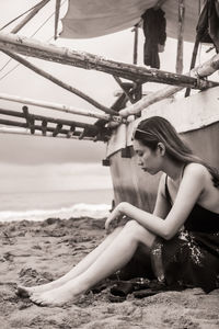 Low angle view of woman sitting on beach