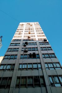 Low angle view of modern building against blue sky