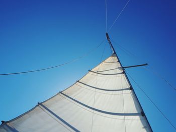 Low angle view of sailboat against clear blue sky