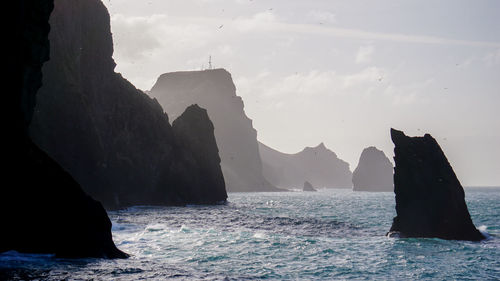 Scenic view of sea and rock formation against sky