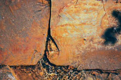 Close-up of rusty wheel on rock