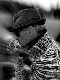 Side view of mature man lighting cigarette outdoors