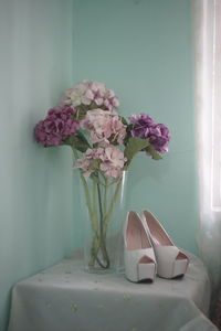 Close-up of flower vase on table against wall at home