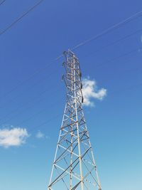 Low angle view of electricity pylon against blue sky