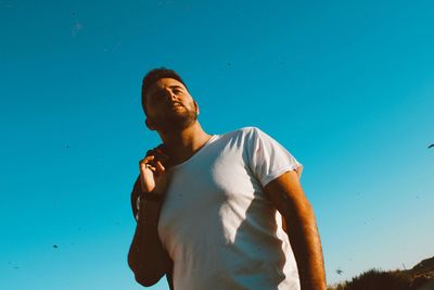 Portrait of young man standing against clear sky