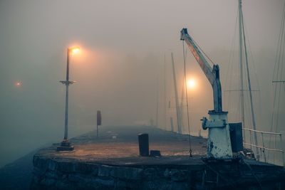 Illuminated commercial dock against sky during sunset