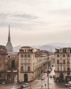 Buildings in city against cloudy sky