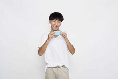 Portrait of smiling man standing against white background