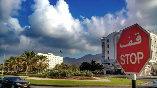 Road sign against cloudy sky