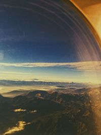 Aerial view of mountain range against cloudy sky