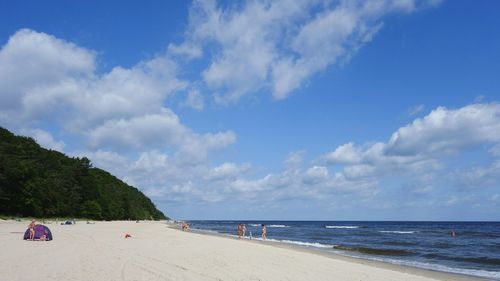 Scenic view of beach against cloudy sky