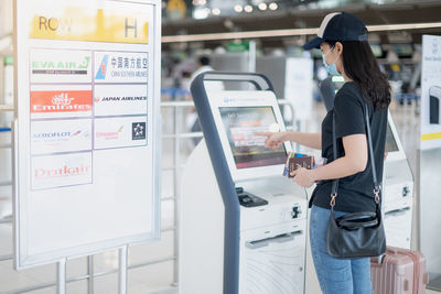 Side view of woman standing on escalator