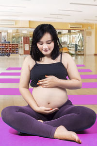 Pregnant woman touching belly at gym