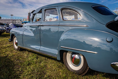 Vintage car parked on field against sky