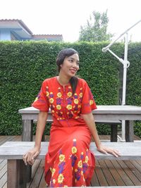 Smiling young woman sitting outdoors