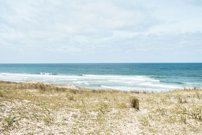 Scenic view of beach and sea against cloudy sky