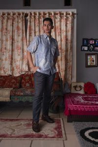 A full length portrait of biracial man in a vintage living room