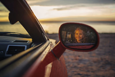 Portrait of girl seen in side view mirror