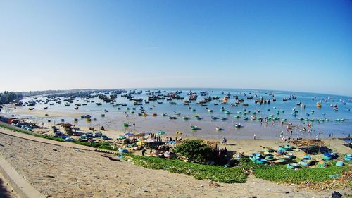 High angle view of people on beach against clear blue sky