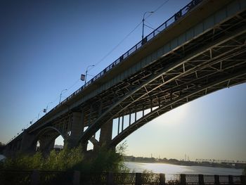 Low angle view of bridge over river against clear sky